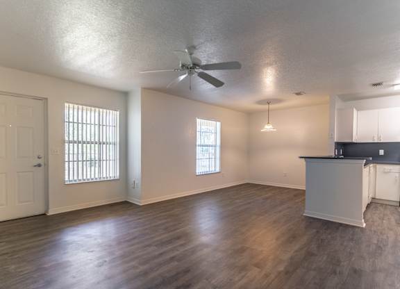 A room with a ceiling fan and wooden flooring.