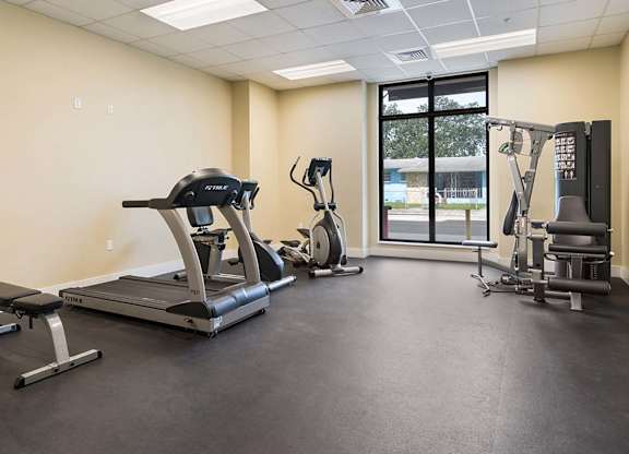 A spacious gym with treadmills, elliptical machines, and other exercise equipment.