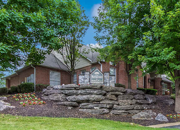 a stone retaining wall in front of a house