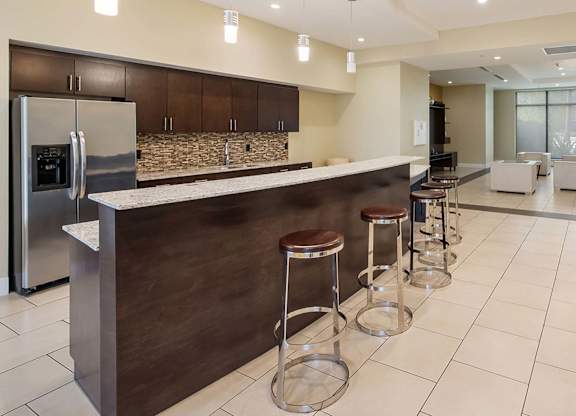 A modern kitchen with a bar area and stools.