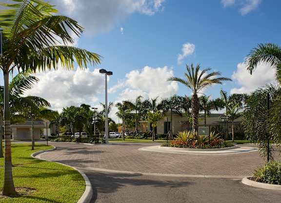 a roundabout with palm trees in front of a building