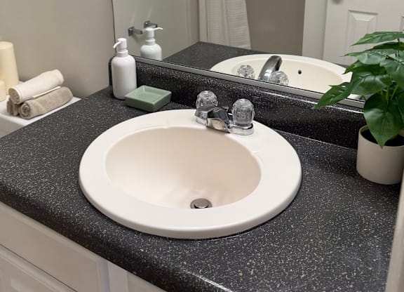 A bathroom sink with a black granite countertop.