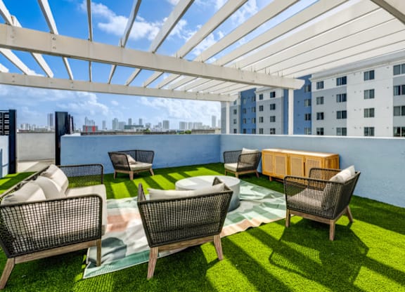 A patio with a white roof and a green lawn.