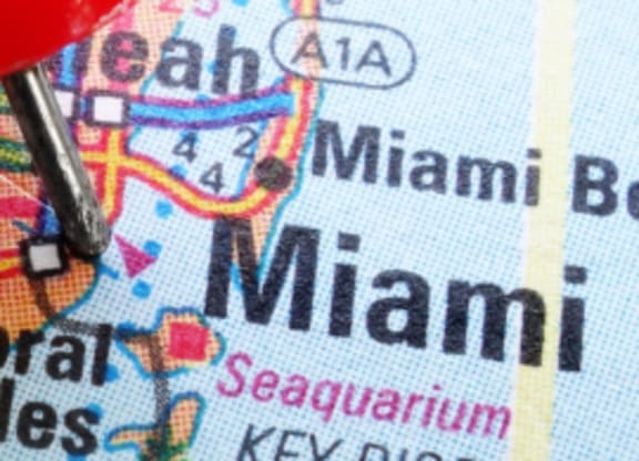 a close up of a map with a red pin in it