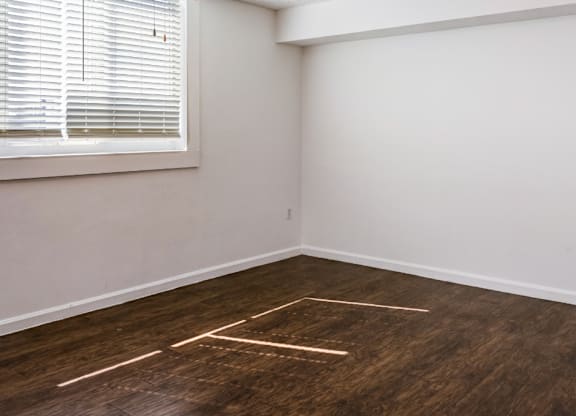 A room with a ceiling fan and a window with blinds.