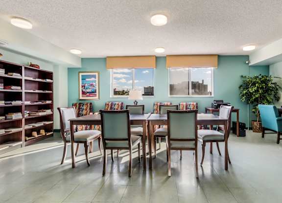 a dining room with a table and chairs and a bookshelf