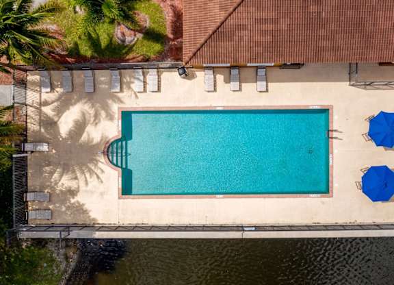 arial view of a swimming pool with blue umbrellas