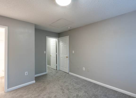 an empty room with two doors and a carpeted floor at Avon Crossings, Durham North Carolina
