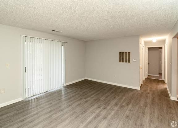 an empty living room with white walls and wood flooring at Avon Crossings, North Carolina, 27713