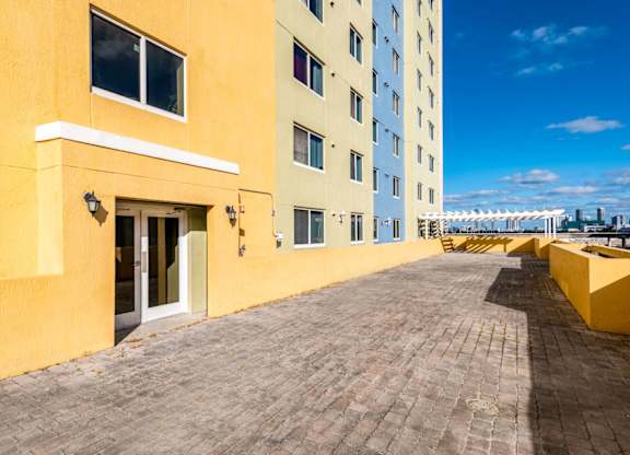 a large yellow building with a brick walkway in front of it
