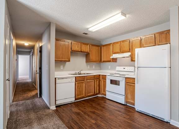A kitchen with white appliances and wooden cabinets.at Brookside Pointe Apartments, Travelers Rest