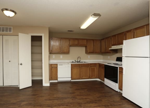 an empty kitchen with white appliances and wooden cabinets at Brookside Pointe, Travelers Rest, South Carolina