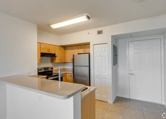 A kitchen with a refrigerator, stove, and oven.