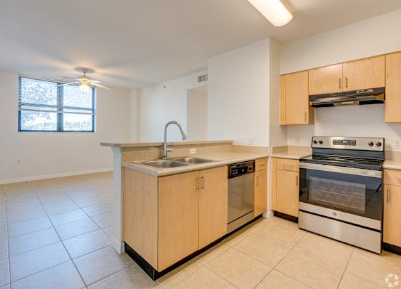 A kitchen with a sink, stove, and oven.