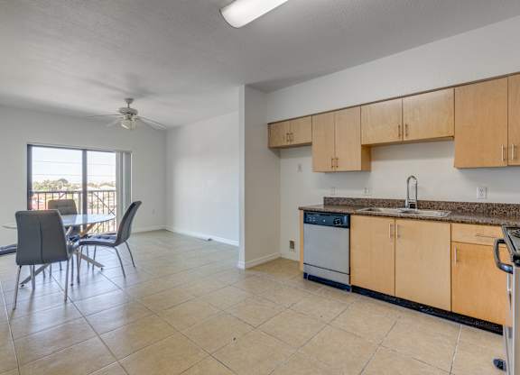 A kitchen with a dining table and chairs is shown.