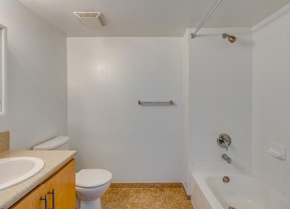 A white bathroom with a toilet, sink, and bathtub.