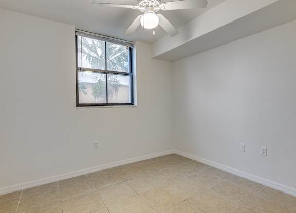 A room with a ceiling fan and a window.