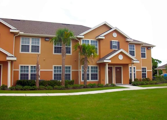 an orange house with palm trees in front of it