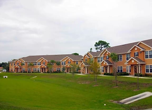 a row of houses on a lush green field