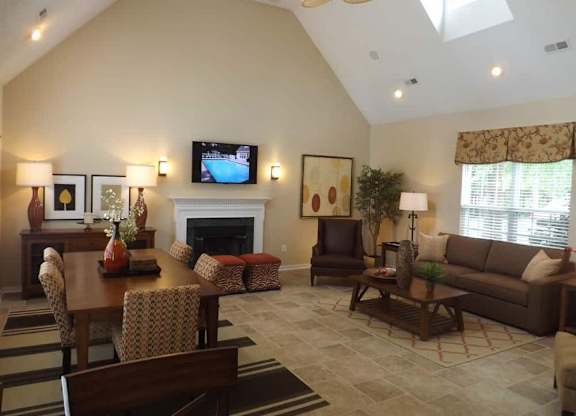 A living room with a fireplace and a television on the wall.