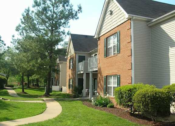 A residential building with a green lawn in front.