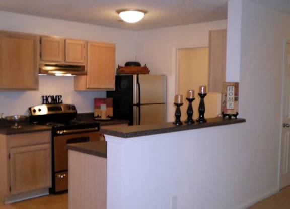 A kitchen with wooden cabinets and a black stove top oven.