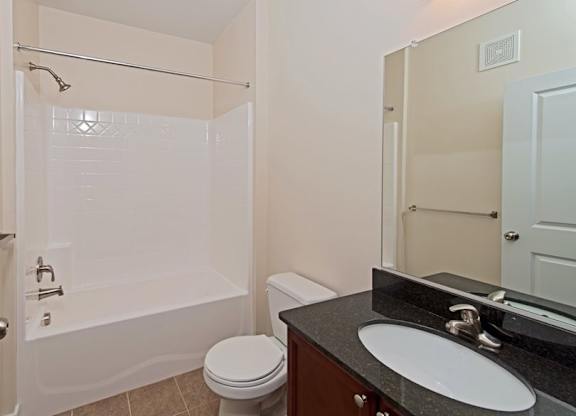 A bathroom with a toilet, sink, and bathtub.