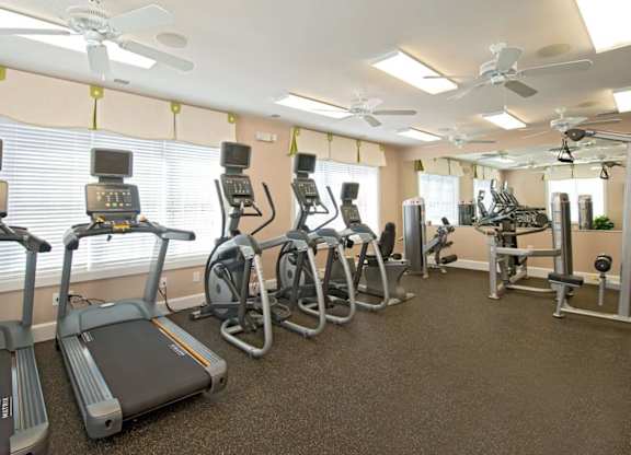 A gym with treadmills, elliptical machines, and other exercise equipment.