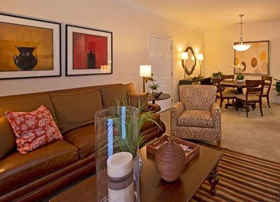 A living room with a brown couch and a red chair.