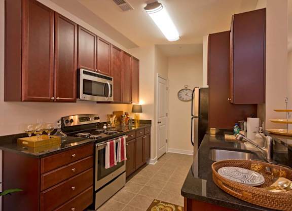 A kitchen with brown cabinets and a black counter top.