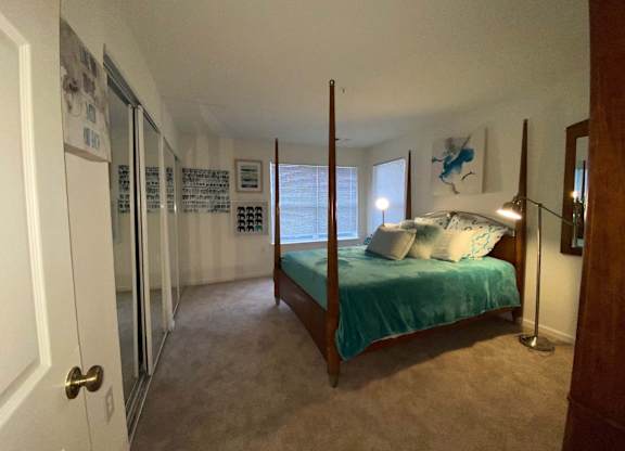 A bedroom with a bed, a dresser, and a mirror.