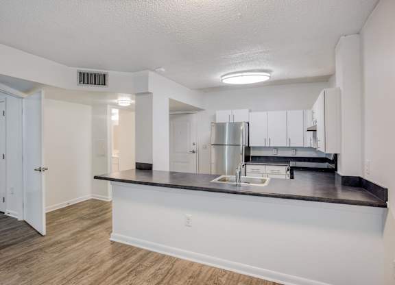 a kitchen with a large island and a stainless steel refrigerator