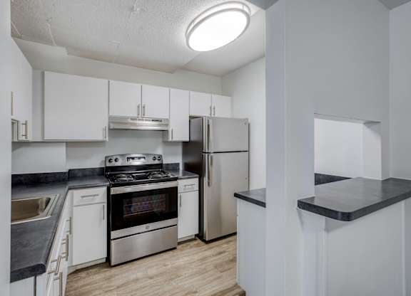 a kitchen with white cabinetry and stainless steel appliances