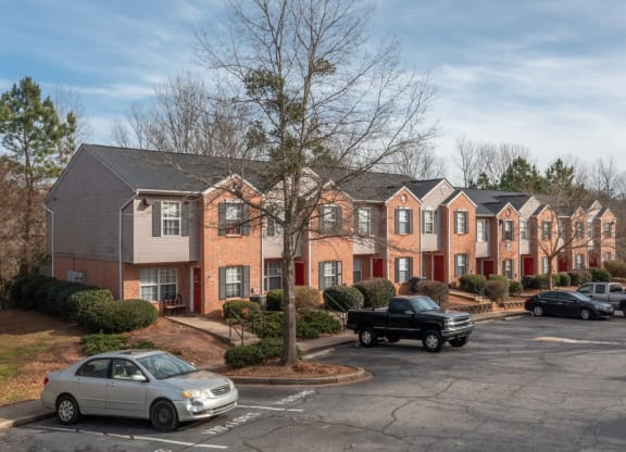 a row of apartment buildings with cars parked in a parking lot at Canaan Pointe, Greenville, 29607