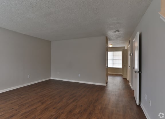 the living room and dining room of an apartment with wood flooring and grey walls at Canaan Pointe, South Carolina