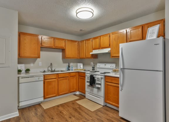 a kitchen with white appliances and wooden cabinets at Canaan Pointe, Greenville, South Carolina