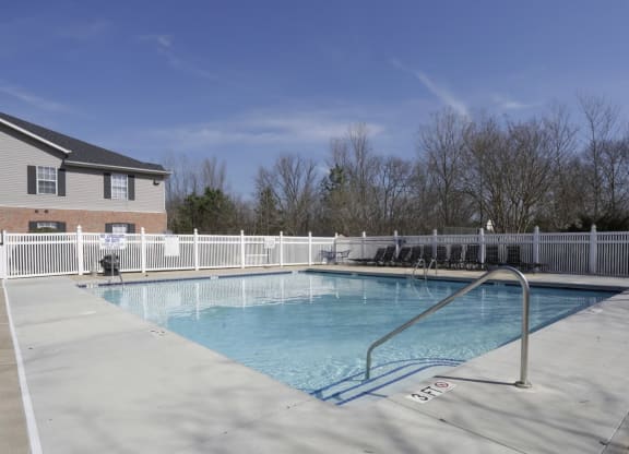 a swimming pool with a fence around it in front of a house at Canaan Pointe, Greenville