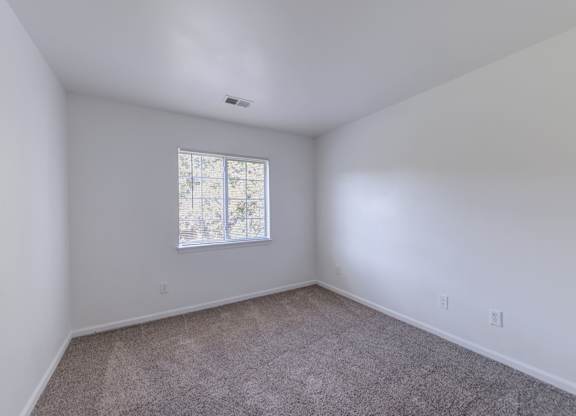 a bedroom with white walls and a window at Carolina Springs Apartments, Carrboro, NC 27510  