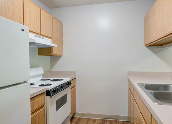 a kitchen with white appliances and wooden cabinets at Carolina Springs Apartments, North Carolina, 27510
