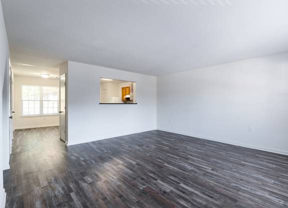 an empty living room with white walls and wood floors at Crescent Pointe Townhomes, Stafford, VA 22554