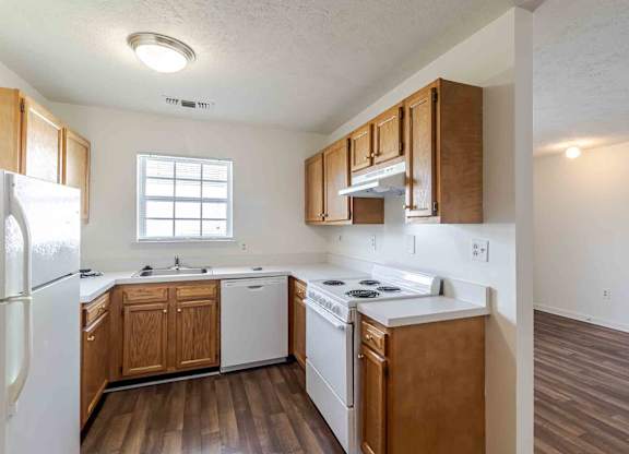 A kitchen with wooden cabinets and white appliances.