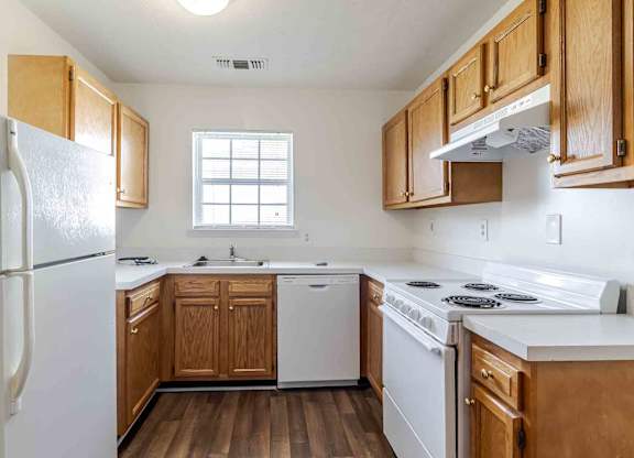 A kitchen with wooden cabinets and white appliances.