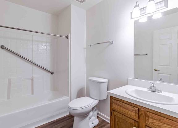 A white toilet sits next to a white sink in a bathroom.