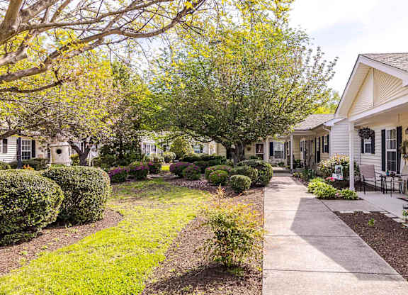 A row of houses with a sidewalk in front.