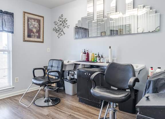 A hairdressing salon with two chairs and a mirror at English Oaks Apartments, Fredericksburg, Virginia