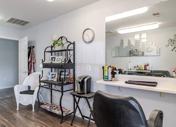A room with a desk, chair, and a clock on the wall at English Oaks Apartments, Fredericksburg, 22406