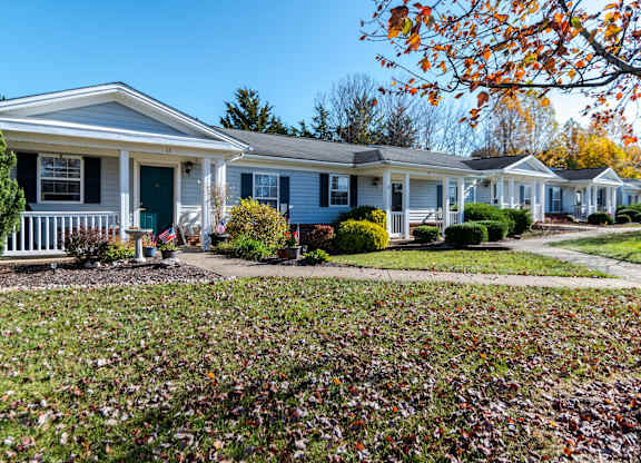 A row of houses with a green lawn in front at English Oaks Apartments, Fredericksburg, VA, 22406