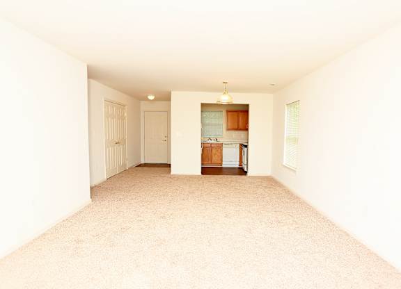 A spacious room with a kitchen area in the background at English Oaks Apartments, Virginia, 22406