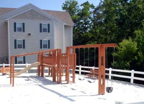 A playground with a slide and swings in front of a house.at Summerland Heights, Woodbridge Virginia  