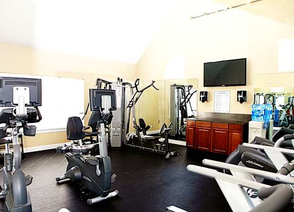 A gym with a variety of exercise equipment including treadmills, stationary bikes, and weight machines.at Summerland Heights, Virginia, 22191